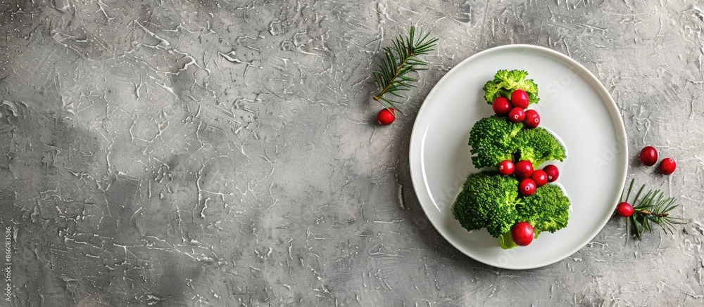 Aufkleber Top view of a festive broccoli and cranberry tree on a white plate, set against a textured grey stone background with ample copy space image.