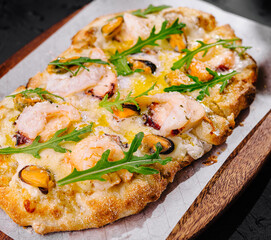 Gourmet shrimp pizza with fresh arugula