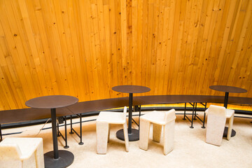 Circle table with chairs for service the customer that near the wooden wall background at cafe restaurant. 