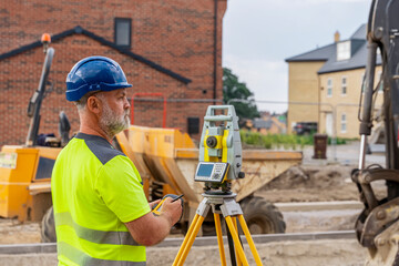 Construction Worker Using Surveying Equipment at Construction Site