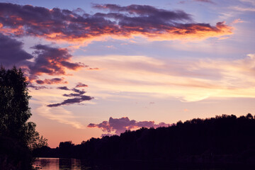 beautiful lilac sunset with clouds on the riverbank