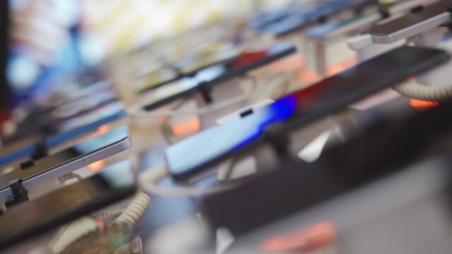 A lot of smartphone models on display at the exhibition stand of an electronics store