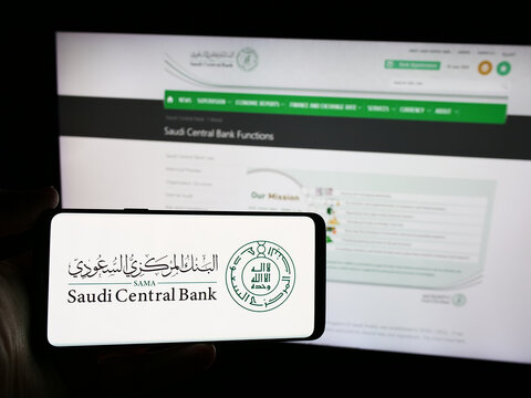 Stuttgart, Germany - 06-14-2024: Person holding smartphone with logo of financial institution Saudi Central Bank (SAMA) in front of website. Focus on phone display.
