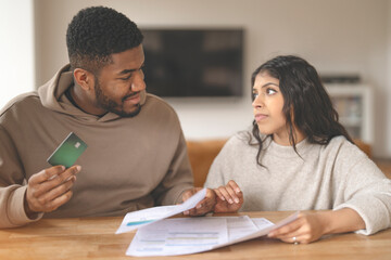 Fototapeta premium Couple Discussing Finances While Holding Credit Card and Bills