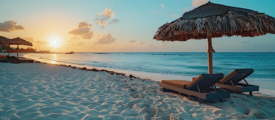 Copy space image of an empty beach lounge on the serene Arashi Beach in Aruba during sunset