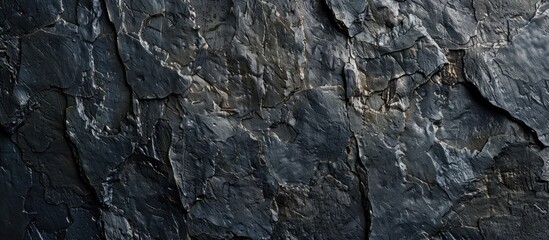 A wall with a textured black surface featuring shadowed edges, suitable for a copy space image.