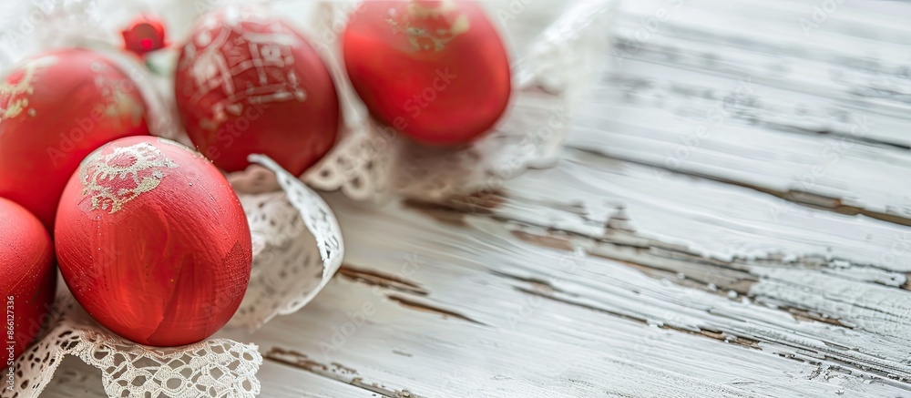 Poster Close-up image of red Easter eggs on white wooden background with lace tape, creating a festive still life with copy space image.
