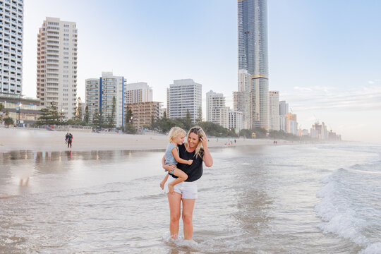 Mother and son playing in shallow water on Main Beach, Surfers Paradise on the Gold Coast