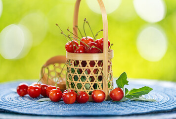 Red Cherry fruit in bamboo basket on on green bokeh background, Japanese Red highest variety of cherries on wooden table in the garden.