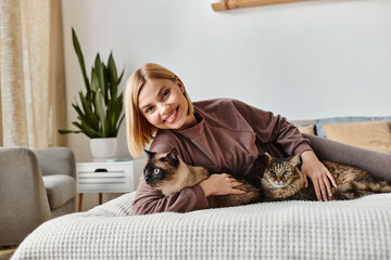 A woman with short hair relaxing on a bed, cuddling with two cats at home in a peaceful moment.