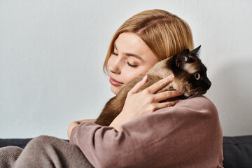 A woman sitting on a couch with short hair, tenderly holding her cat in a serene and cozy home setting.