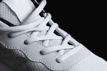 White laces on a sneaker close-up on a dark background, sports concept, men's fashion, sports...