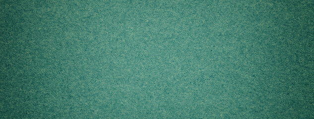Texture of vintage dark green paper gradient background with dark vignette. Craft emerald cardboard