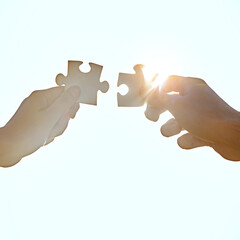 Hands, sky and people fitting puzzle pieces together outdoor from below for synergy or team building. Assemble, partnership or teamwork with inclusion and business jigsaw for connection or solidarity