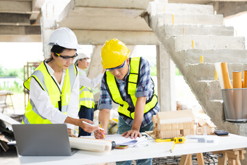 Engineer teams meeting working together wear worker helmets hardhat on construction site in city.