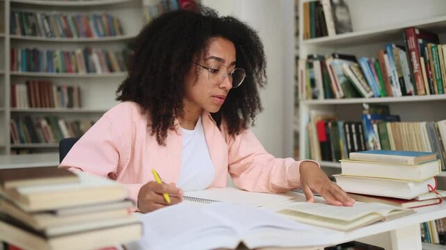 Boring curly student girl feeling tired during study at university library Stressed young woman exhausted from remote distance work or education hard program indoors