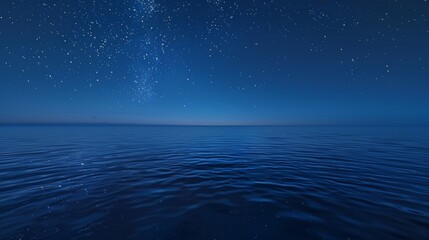Deep blue sea at twilight with stars beginning to appear in the sky, reflecting on the calm water
