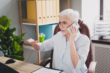 Photo of anxious age lady recruiter dressed formal shirt talking modern gadget indoors workplace...