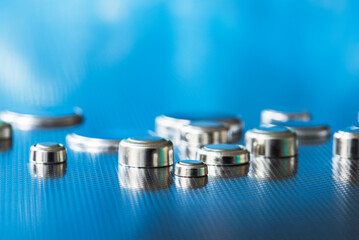 Set of flat lithium round button cell battery on metal surface