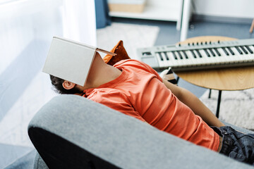 Young musician falling asleep while studying music theory