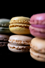 French colored macaroons in two rows on a dark background