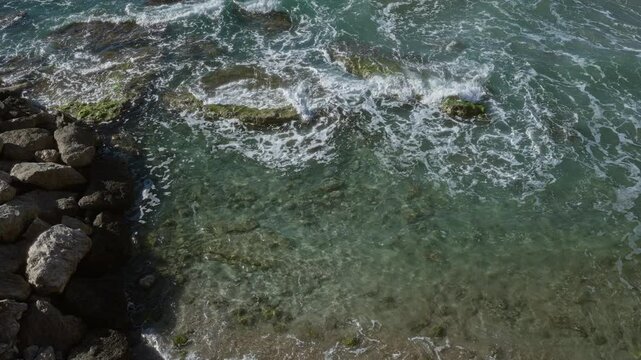 Clear turquoise waters of gallipoli, puglia, italy, splashing against rocks create a serene coastal scene