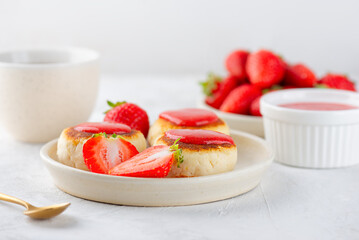 Cheesecakes, syrniki, cheese pancakes with strawberries, berries jam, cashew, tofu and cup of tea. Vegan food. Sugar, lactose and gluten free.
