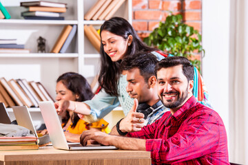 Indian asian four college or university students using laptop together