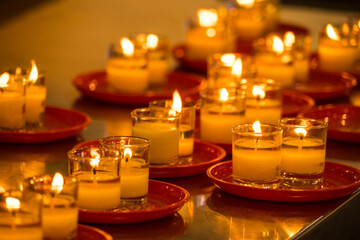 Lit Prayer Candles Close Up in Black Background. Hope and Successful Concept.