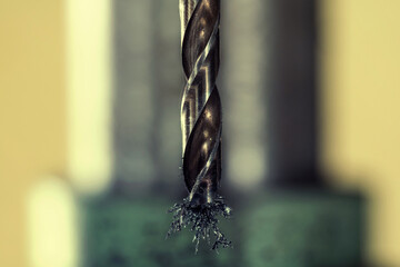 Industrial machinery. Detail of a drill bit with metal shavings sticking.