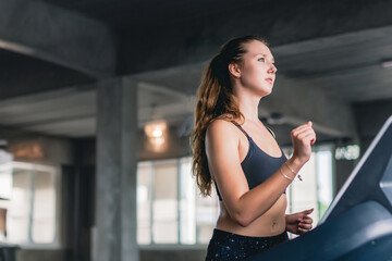 Side profile view young skinny strong sporty athletic sportswoman woman in white sportswear warm up training run on treadmill in gym indoors Workout sport motivation