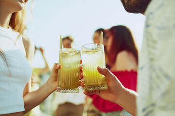 Cool summer vibe. Close-up of two friends toasting with various beverages, capturing t joy and camaraderie of moment. Concept of party, Friday mood, celebration, summer holidays, relax.
