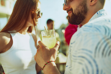 Laughter and joy abound as friends come together for toast, their drinks sparkling in sunlight. Group of people outdoor. Concept of party, Friday mood, celebration, summer holidays, relax.