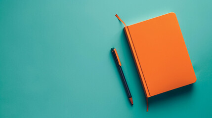 An orange notebook positioned in the bottom right corner of a solid teal background, ready for note-taking.