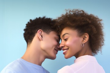 Fototapeta premium Couple, age 18, African American, sharing a tender moment, first love, pastel blue background