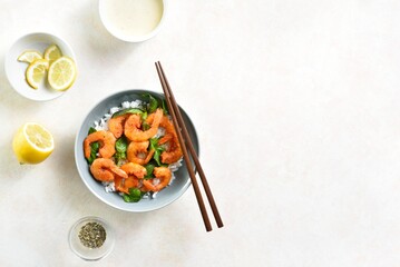 Roasted prawn with basil leaves and rice in bowl over light background