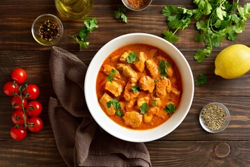  Indian dish chicken tikka masala in bowl on wooden background