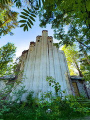 A captivating image of an abandoned church wall framed by lush green foliage and set against a...