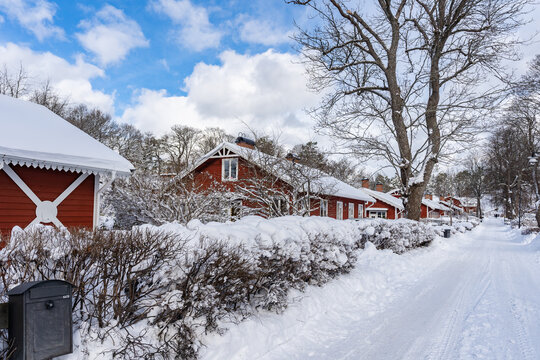 Traditional old big red wooden house in winter countryside. Beautiful Swedish cottage or villa . Christmas landscape in northern Europe. Snowy village.