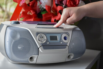 Homeowner is pressing play panel of the cd deck with his fingers to play music from his favorite cd...