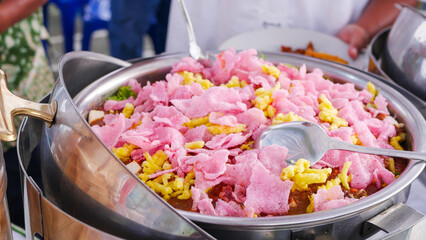 A bowl of delicious food featuring pink and yellow shrimp crisp toppings, perfect for a large gathering dish.