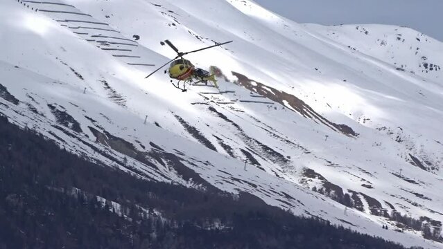 Helicopter search and rescue emergency accident evacuation flying directly to the camera head on before turning mountain winter background