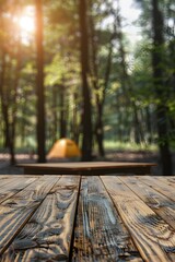Wooden table top with camping tents in a forest background, for a product display montage or banner design.