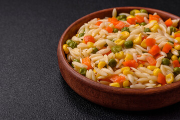 Delicious boiled rice with vegetables corn, carrots, peas with salt