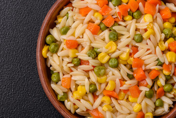 Delicious boiled rice with vegetables corn, carrots, peas with salt