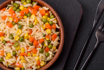 Delicious boiled rice with vegetables corn, carrots, peas with salt