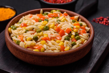 Delicious boiled rice with vegetables corn, carrots, peas with salt