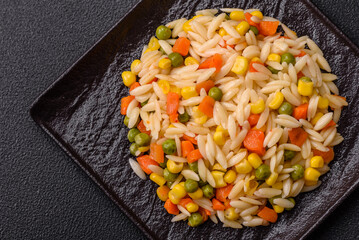 Delicious boiled rice with vegetables corn, carrots, peas with salt