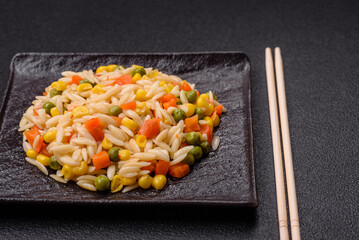 Delicious boiled rice with vegetables corn, carrots, peas with salt