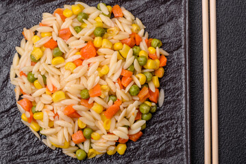 Delicious boiled rice with vegetables corn, carrots, peas with salt